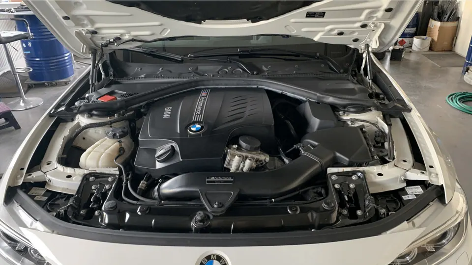 Lack Attacke Service - Geöffneter Motorraum eines BMW-Fahrzeugs nach der Reinigung